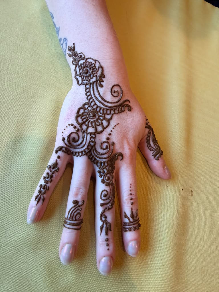 Dense floral henna designs on both hands